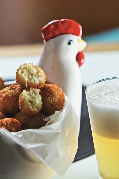 Uma simpática galinha de cerâmica serve de travessa para os salgados em tamanho míni, com queijo gorgonzola na massa