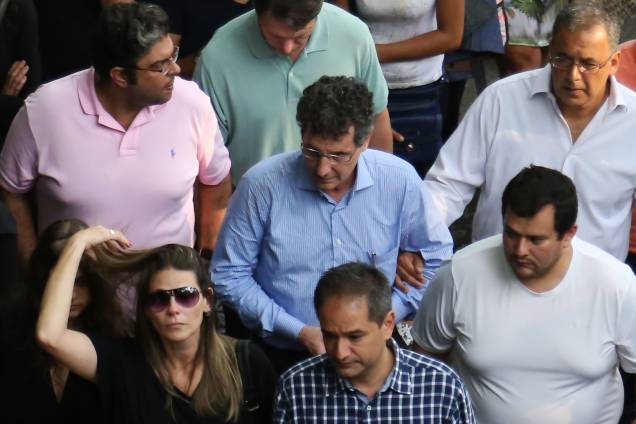 Alexandre Landini (de azul) amparado por parentes e amigos no enterro da mulher e do filho Alexandre Landini (de azul) amparado por parentes e amigos no enterro da mulher e do filho