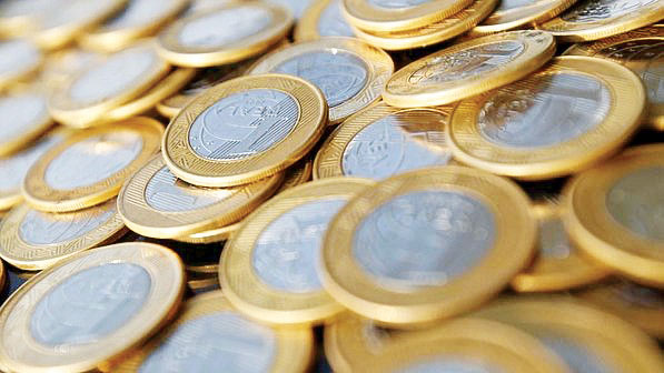 A imagem mostra moedas de um real.