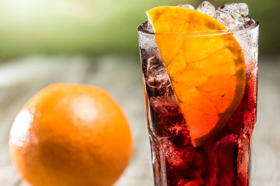 Drinque americano por Laércio Zulu: usando bitters, vinho modificado com infusão de ervas e água com gás aromatizada com limão Drinque americano por Laércio Zulu: usando bitters, vinho modificado com infusão de ervas e água com gás aromatizada com limão