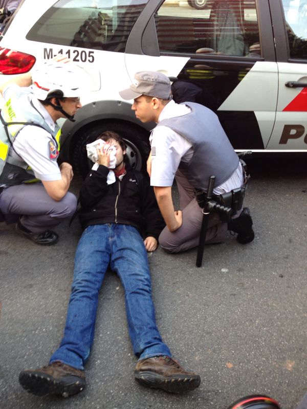Manifestante atingido por bala de borracha é socorrido por policiais Manifestante atingido por bala de borracha é socorrido por policiais