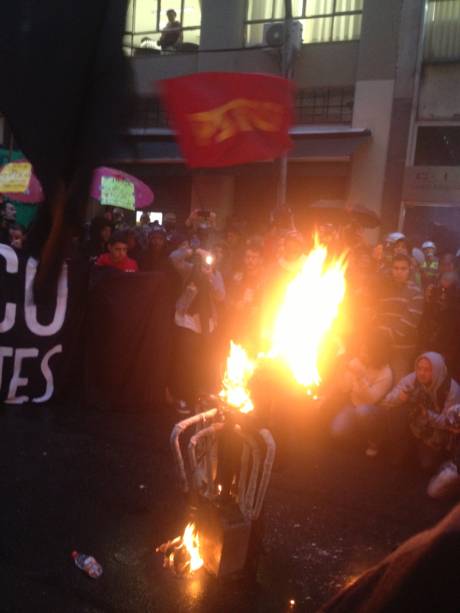 	Em frente à Secretaria dos Transportes, os manifestantes atearam fogo em uma catraca de ônibus falsa. O ato segue pacífico