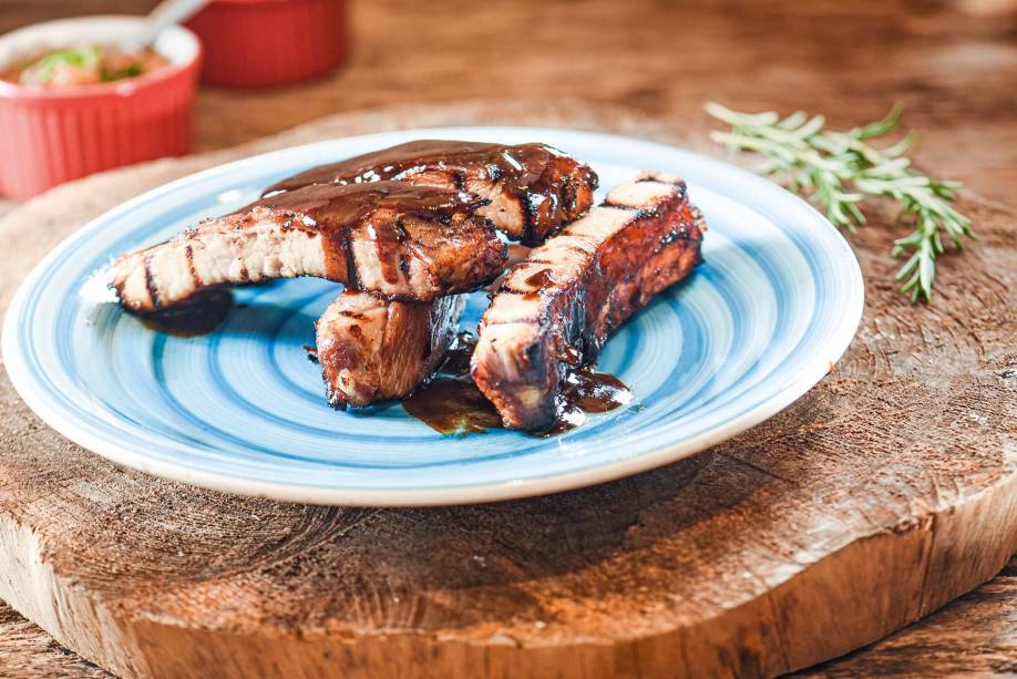 As macias costelinhas de porco chegam soltando do osso e besuntadas de molho barbecue