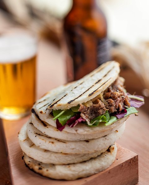 Arepa de carne com chipotle, cebola e rúcula