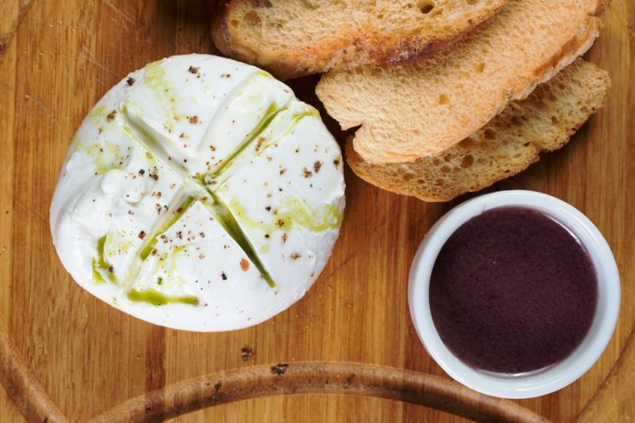 A burrata vem acompanhada de tapenade e torradas