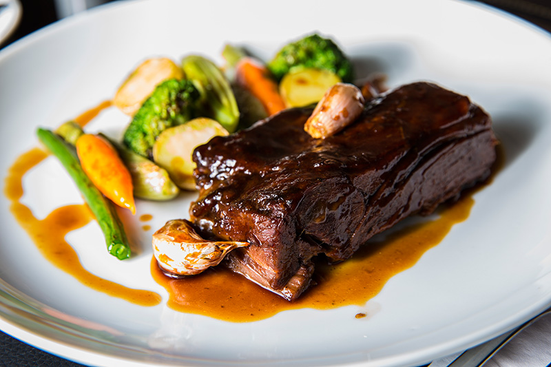 Lentamente assado, o cabrito vai para a panela para ser cozido e ganha a companhia de legumes ao forno