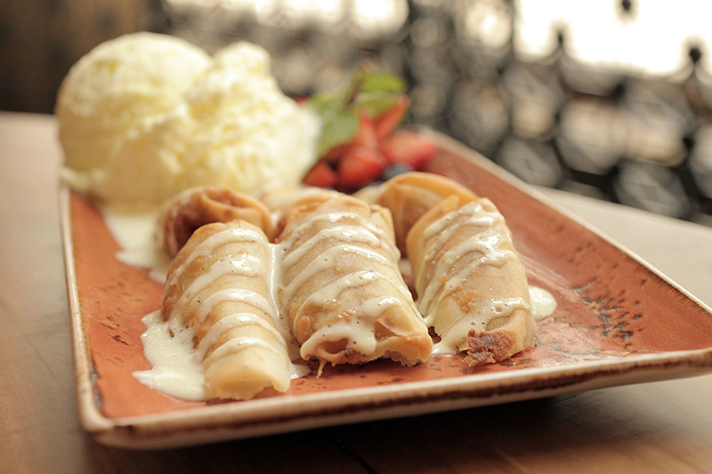 A banana caramelada é coberta por caldas de caramelo e de baunilha, servida com sorvete de abacaxi e coco