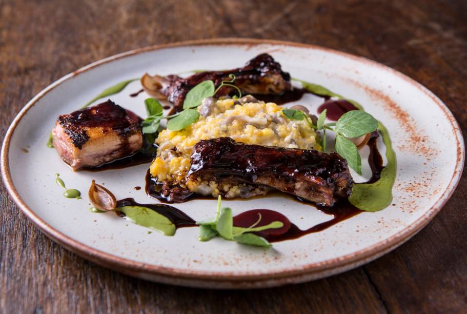 O duo de costelinha e barriga de porco recebe molho de jabuticaba com canjiquinha e cogumelo shimeji O duo de costelinha e barriga de porco recebe molho de jabuticaba com canjiquinha e cogumelo shimeji