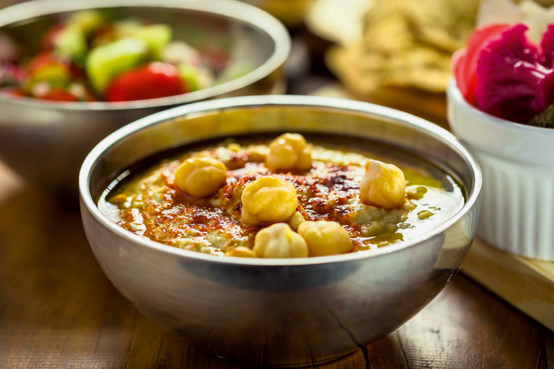 Tigela de homus com uma camada generosa de azeite e páprica Tigela de homus com uma camada generosa de azeite e páprica