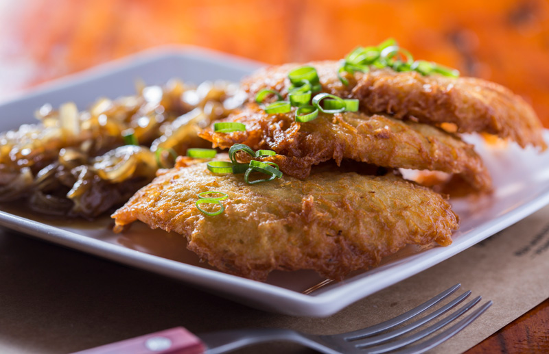 kartoffelpuffer: três panquequinhas do batata ralada crocantes com cebola caramelada