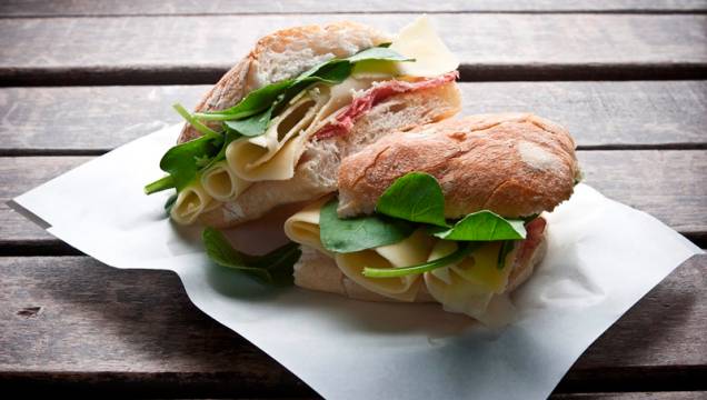 O sanduíche de rúcula, copa e queijo emmental é montado no pão ciabatta O sanduíche de rúcula, copa e queijo emmental é montado no pão ciabatta