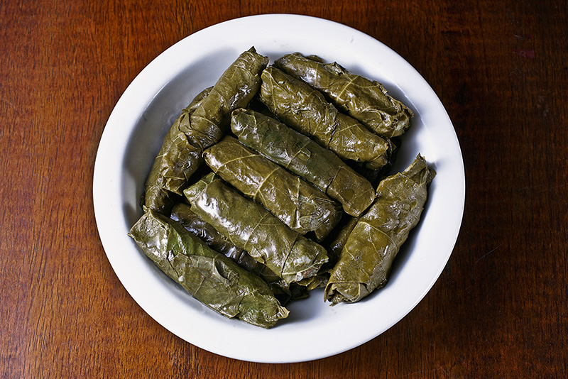 Porção de charutinhos de folha de uva perfeitamente enrolados Porção de charutinhos de folha de uva perfeitamente enrolados