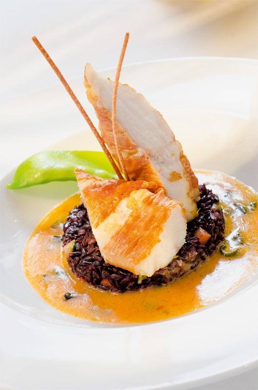 Peixe tamboril: envolto em presunto cru com emulsão de sálvia e arroz negro