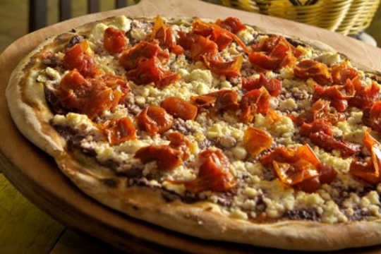 A pizza Mediterrâneo é feita com finas fatias de berinjela, tomate seco picadinho e ricota regada ao pesto de azeitona preta A pizza Mediterrâneo é feita com finas fatias de berinjela, tomate seco picadinho e ricota regada ao pesto de azeitona preta