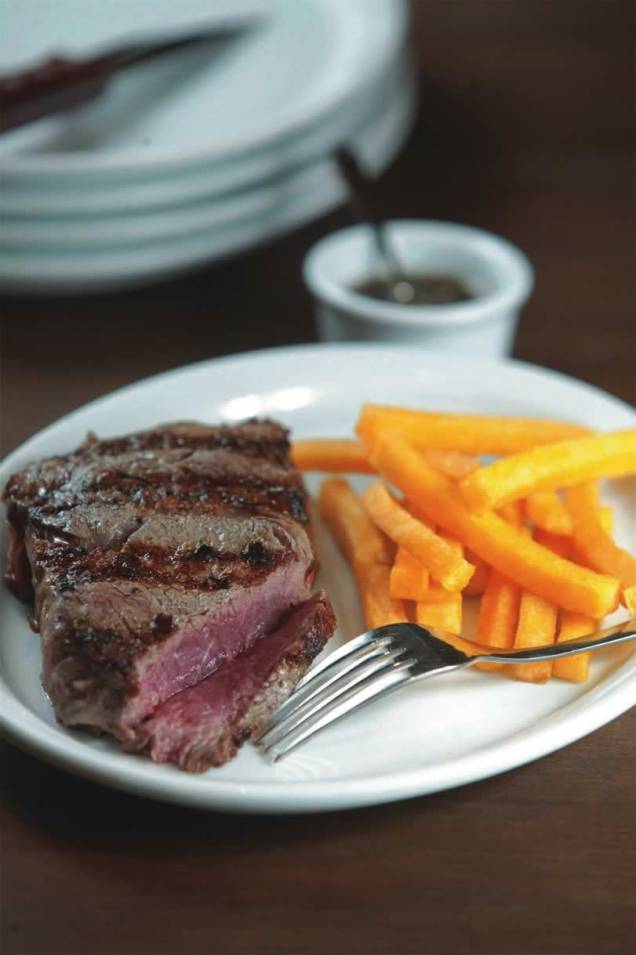 Da grelha inclinada do Portucho: o bife ancho pode vir acompanhado de palitos de polenta frita Da grelha inclinada do Portucho: o bife ancho pode vir acompanhado de palitos de polenta frita