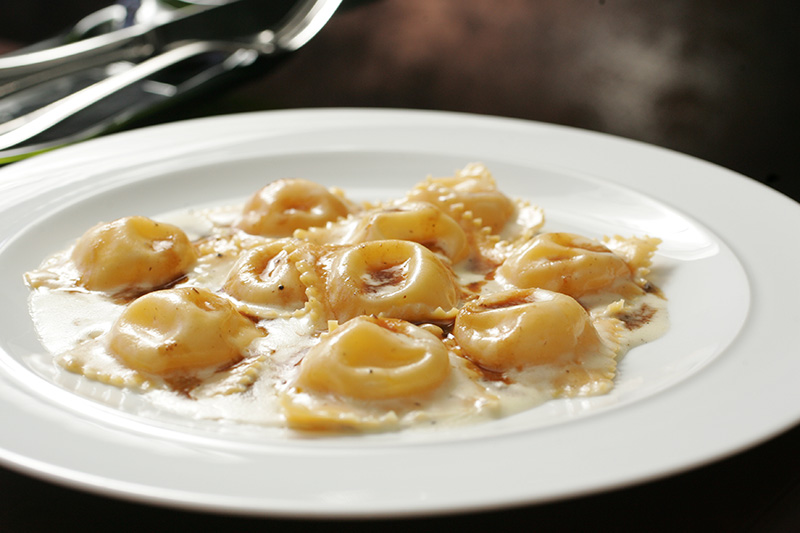Tortelli de queijo brie ao creme de parmesão aromatizado por manteiga de trufa branca e molho rôti Tortelli de queijo brie ao creme de parmesão aromatizado por manteiga de trufa branca e molho rôti