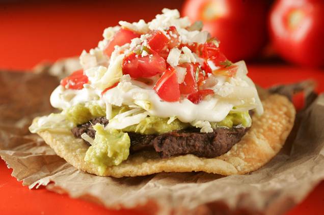 Entre os petiscos para comer com as mãos, está a tostada tradicional de pasta de feijão Entre os petiscos para comer com as mãos, está a tostada tradicional de pasta de feijão