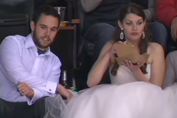 Melhor casal do mundo é flagrado comendo hambúrgueres e assistindo a um jogo no dia do casamento