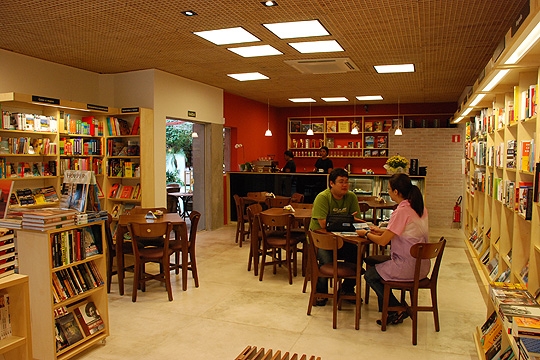 Livraria Capítulo 4 com mesinhas próximas às prateleiras Livraria Capítulo 4 com mesinhas próximas às prateleiras