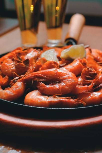 A farta chapa camarão do Devassa: crustáceo frito com casca sobre lâminas de alho A farta chapa camarão do Devassa: crustáceo frito com casca sobre lâminas de alho
