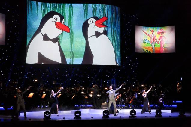 Ao fundo do palco, cenas das películas são reproduzidas em um telão Ao fundo do palco, cenas das películas são reproduzidas em um telão