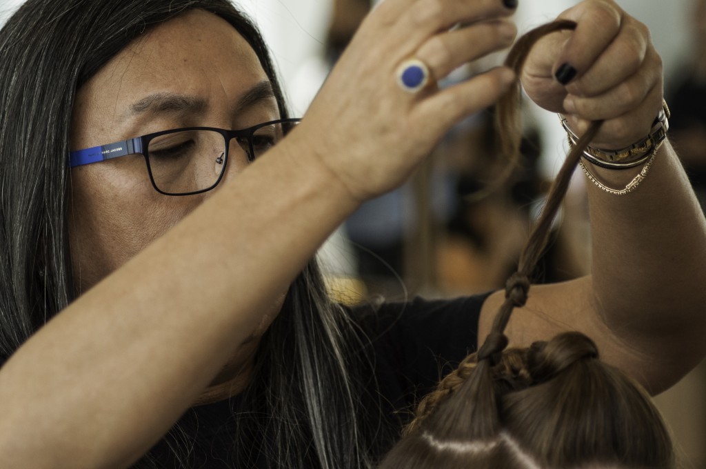 Com a parte lateral dos cabelos, o harstylist pega pequenas mechas e faz nós simétricos em toda extensão do cabelo.