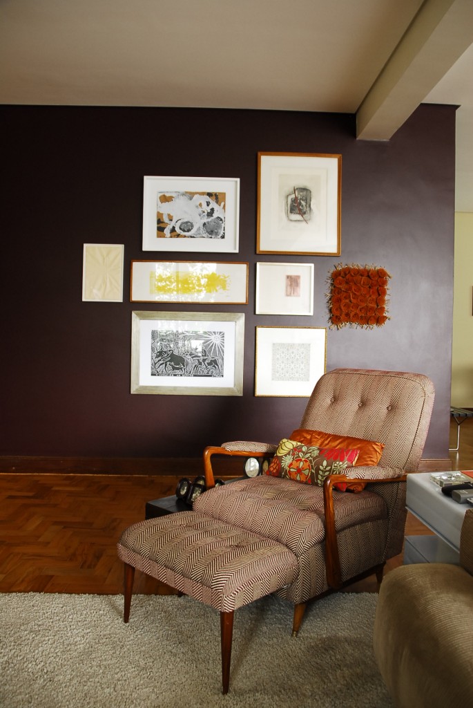 Ao lado da poltrona, o aspirador de p&oacute; antigo funciona como mesa de apoio