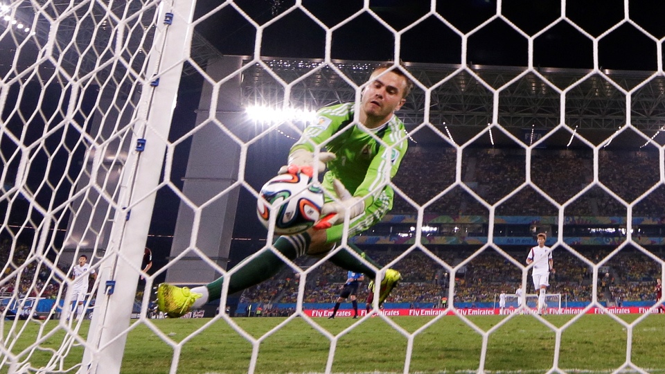 O goleiro russo Igor Akinfeev engole o frango, quer dizer, a bola dispara por Lee Keun-ho da Coreia do Sul durante o jogo realizado na Arena Pantanal em Cuiabá em 17 de junho de 2014. (AP Photo/Lee Jin-Man)