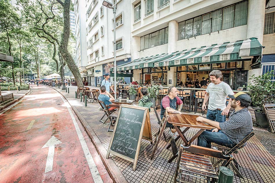 Pessoas na calçada em bar