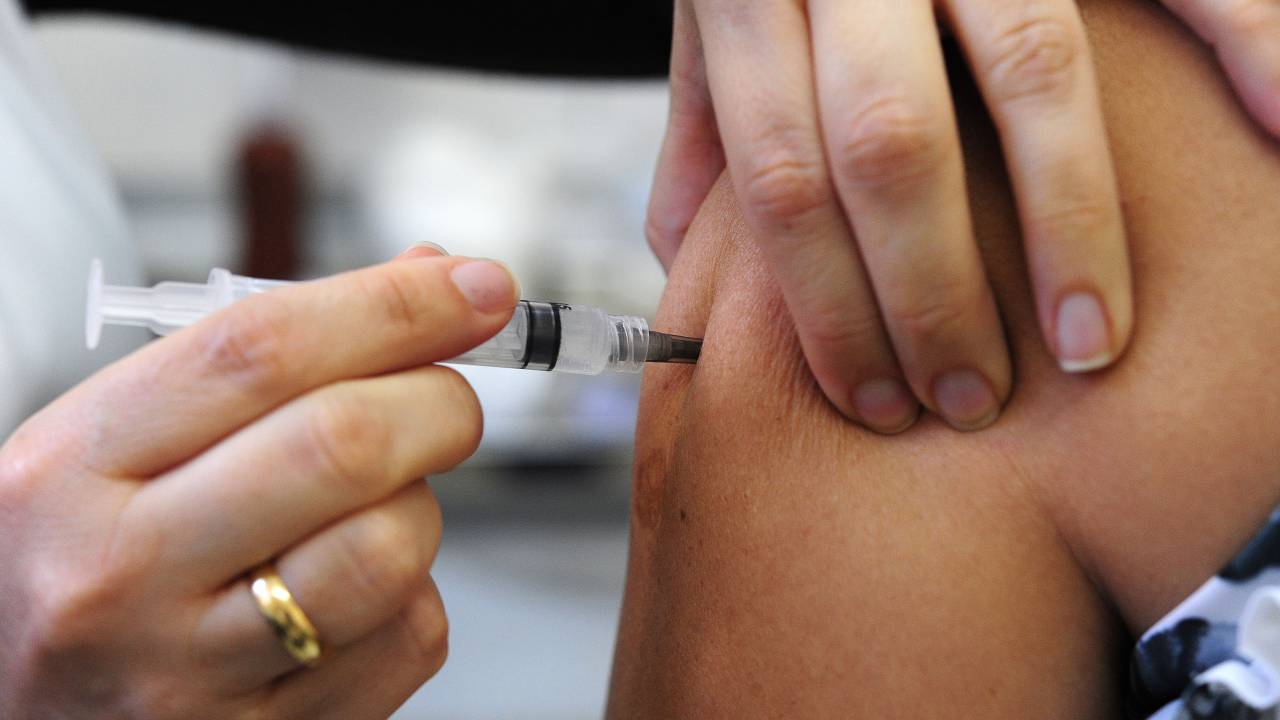 Imagem mostra enfermeira aplicando vacina no braço de paciente