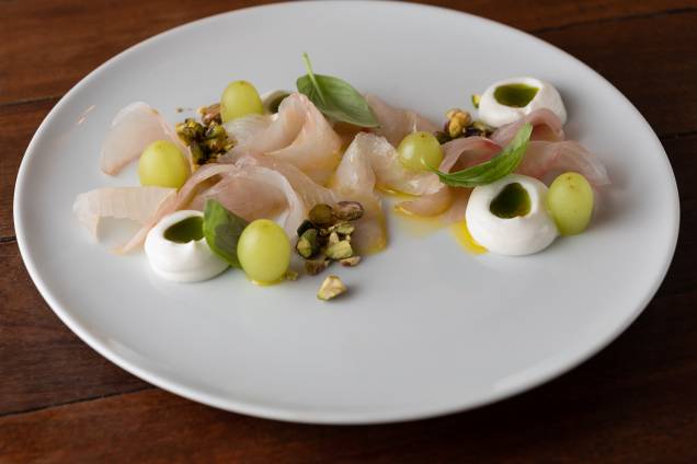 Amateigado de tão macio: crudo de robalo com azeite aromatizado por manjericão, uvas verdes, pistache e creme de ricota Amateigado de tão macio: crudo de robalo com azeite aromatizado por manjericão, uvas verdes, pistache e creme de ricota