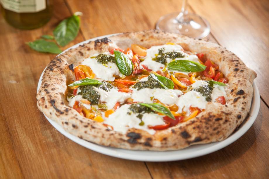 Pizza de burrata com tomatinhos vermelhos e amarelos, pesto e manjericão Pizza de burrata com tomatinhos vermelhos e amarelos, pesto e manjericão