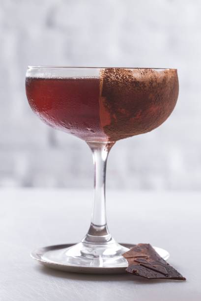 Manhattan chocolat: releitura do clássico com bourbon, leva vermute com infusão de cacau e bitter de notas torradas, servido na taça polvilhada de cacau