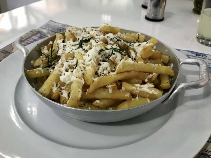 Para petiscar: batatas fritas salpicadas de ervase queijo feta Para petiscar: batatas fritas salpicadas de ervase queijo feta