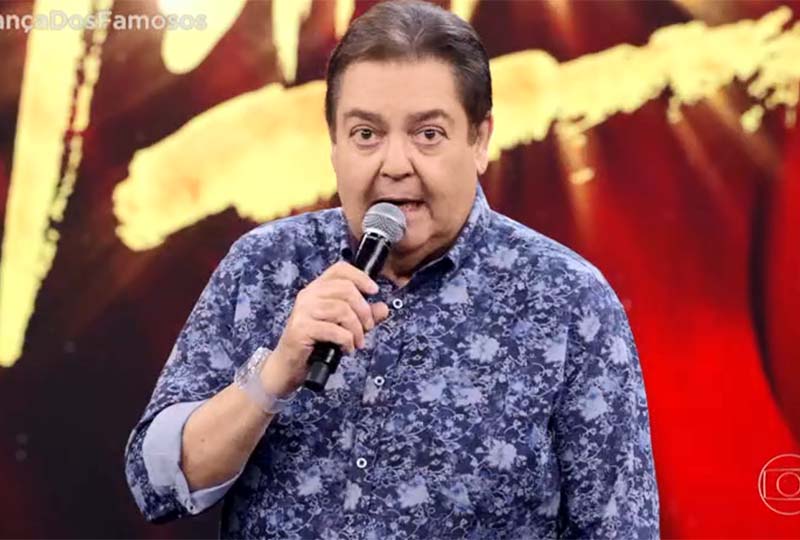 A imagem mostra Faustão apresentando o Domingão