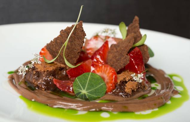 Sobremesa de chocolate: com diversas texturas, o doce combina bolo denso, creme, musse e um crocante com morangos infusionados em tequila e azeite de coentro Sobremesa de chocolate: com diversas texturas, o doce combina bolo denso, creme, musse e um crocante com morangos infusionados em tequila e azeite de coentro