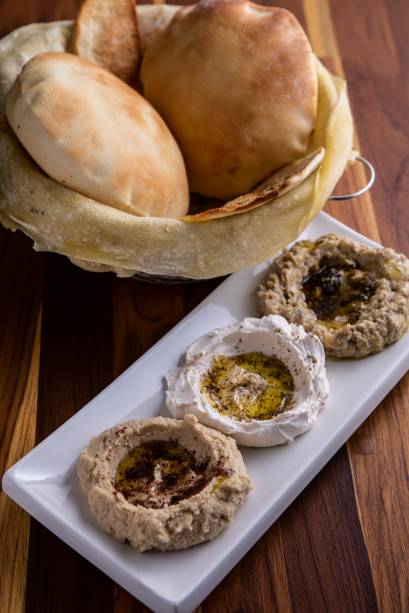 Trio de pastas: homus, coalhada seca e babaganuche, com pão saj à parte