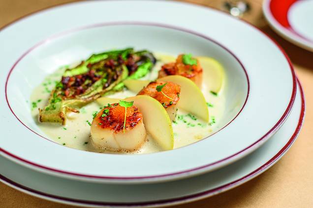 Trio de vieiras: grelhadas e guarnecidas com caldo de peixe ao gengibre, fatias de pera, ovas de peixe-voador, alface-romana grelhada e cubos de bacon Trio de vieiras: grelhadas e guarnecidas com caldo de peixe ao gengibre, fatias de pera, ovas de peixe-voador, alface-romana grelhada e cubos de bacon