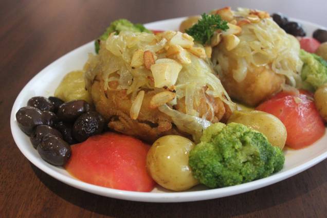 Bacalhau à lagareiro: posta do peixe assada e guarnecida de alho, batatinha ao murro, brócolis, tomate e azeitona Bacalhau à lagareiro: posta do peixe assada e guarnecida de alho, batatinha ao murro, brócolis, tomate e azeitona