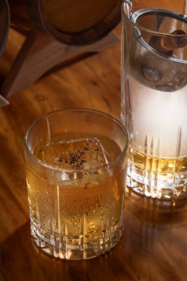 Primeiro fuxico: composto de rum nacional passado por jequitibá, vermute doce e vinho branco fortificado com ervas, defumado com especiarias e chá preto Primeiro fuxico: composto de rum nacional passado por jequitibá, vermute doce e vinho branco fortificado com ervas, defumado com especiarias e chá preto