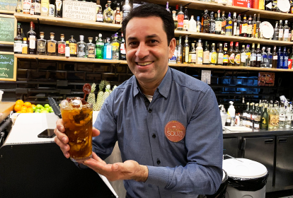 Homem segura caipirinha em bar