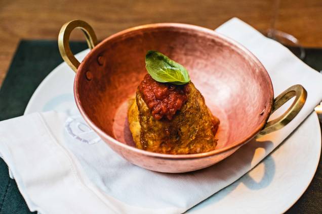 Berinjela à parmigiana: prato siciliano com fatias do vegetal fritas e molho de tomate Berinjela à parmigiana: prato siciliano com fatias do vegetal fritas e molho de tomate