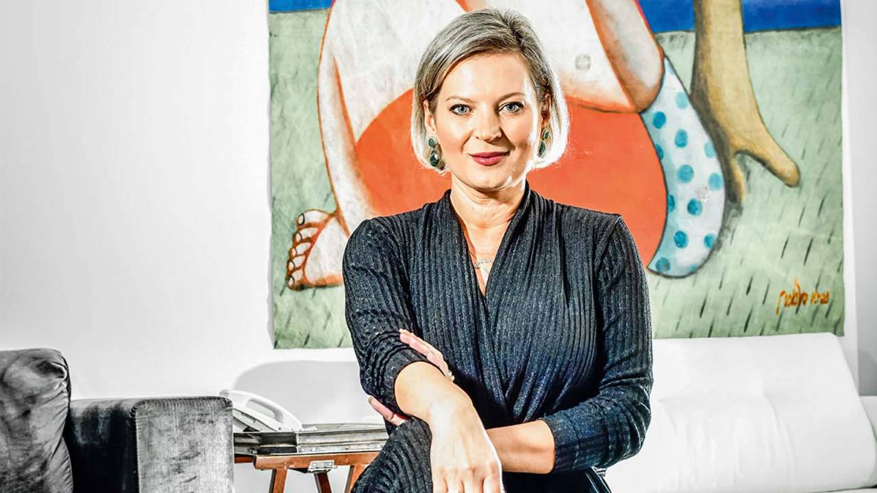 Imagem mostra Joice posando diante de quadro