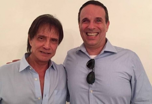 Imagem mostra Roberto Carlos ao lado do filho, Dudu Braga, que sorri
