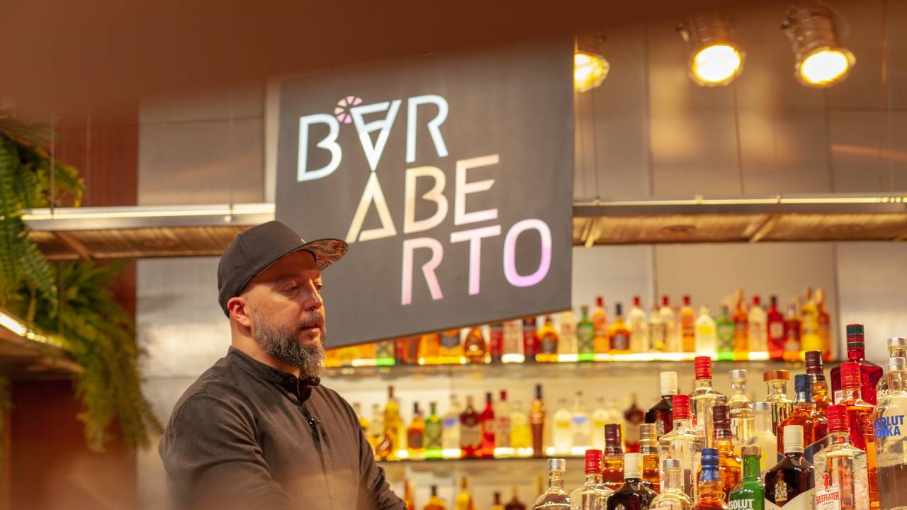 Homem de boné em frente a bar