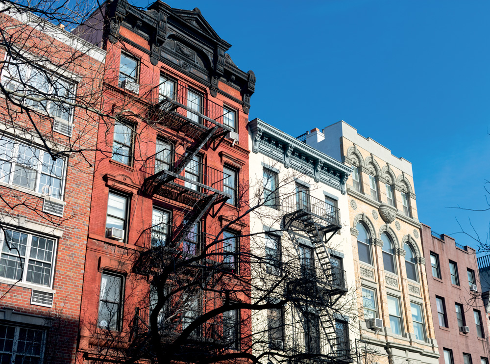 Colorful Old Buildings in the East Village of New York City with Fire Escapes A row of colorful old brick buildings with fire escapes in the East Village of New York City