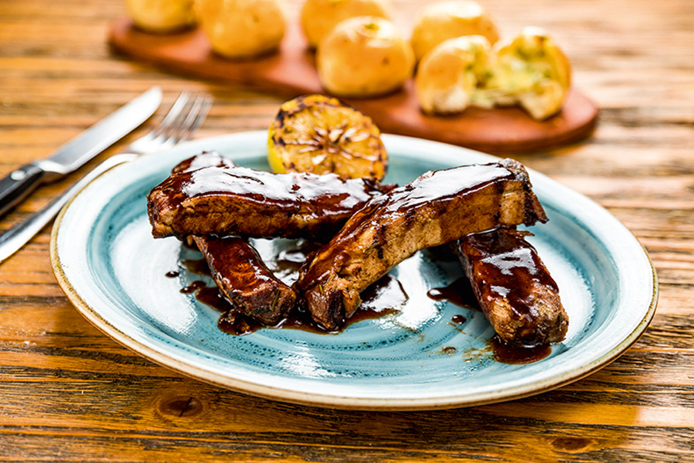 As macias costelinhas de porco chegam besuntadas de molho barbecue