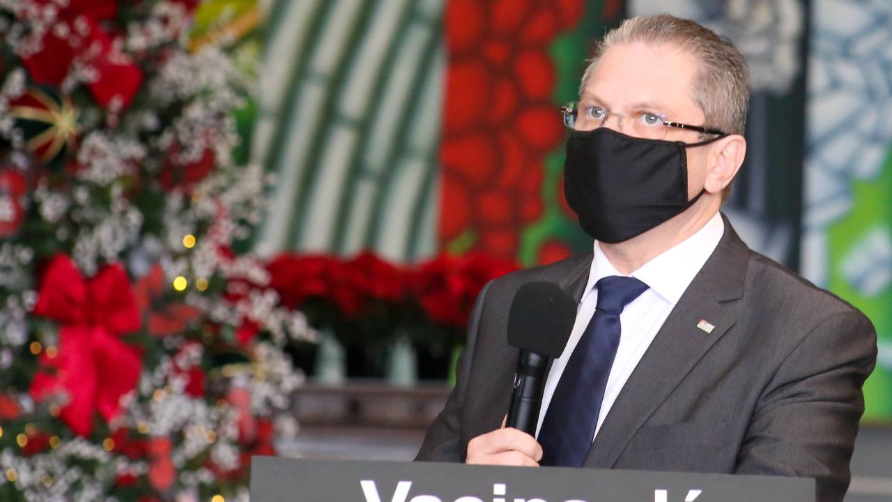 Imagem do secretário Jean Gorinchteyn falando ao microfone em coletiva de imprensa