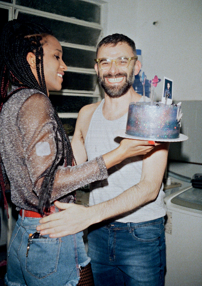 Bárbara segura um bolo de aniversário quando Leo a abraça