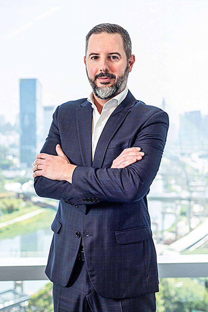 TEGRA – THIAGO CASTRO (DIVULGAÇÃO) Thiago Castro, diretor executivo da Tegra, posa de braços cruzados e terno cinza-escuro.